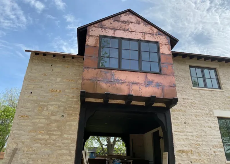 Copper metal panel facade on a stone building for Skylight Installation in Four Square Mile